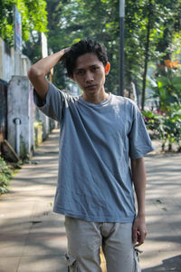 Portrait of young men standing on footpath