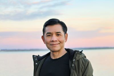 Portrait of young man standing against sky during sunset