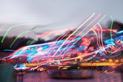 Low angle view of light trails against sky at night