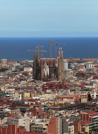 High angle view of townscape by sea against sky