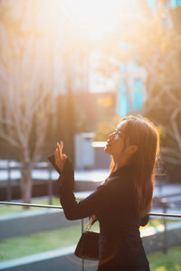 Side view of young woman using mobile phone