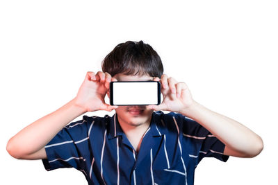 Portrait of man holding smart phone against white background