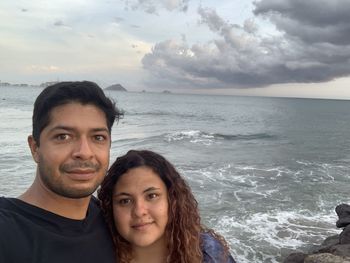 Portrait of smiling woman against sea against sky