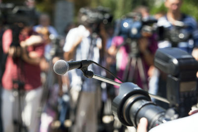 Close-up of microphone against journalists