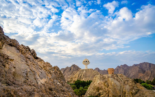 Low angle view of rock formations against cloudy sky