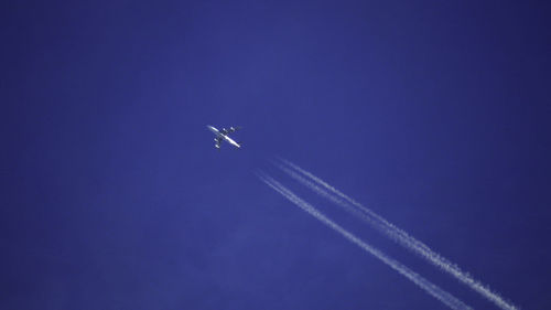 Low angle view of airplane against blue sky