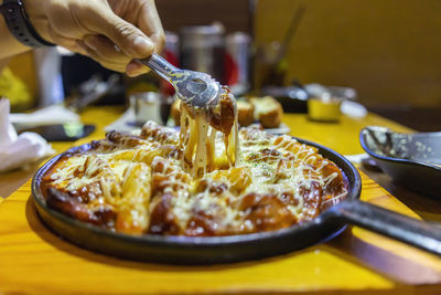 Close-up of hand pouring food on table