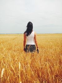 Rear view of woman standing in field