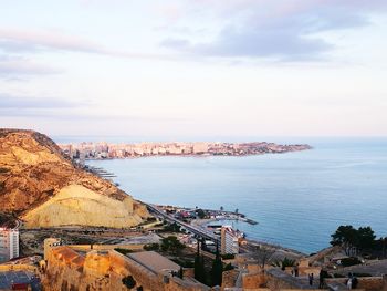 High angle view of buildings by sea against sky