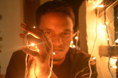 Close-up of woman holding light bulb