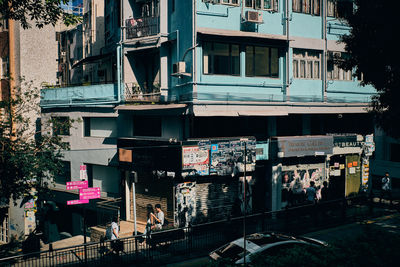 People on street against buildings in city