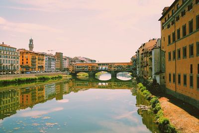 Canal amidst city against sky