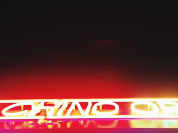 Close-up of neon sign on white wall