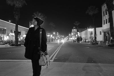 Woman walking on road at night