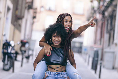 Portrait of smiling young woman on street in city