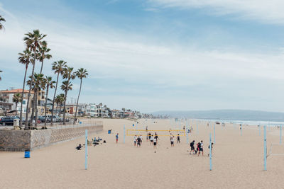 High angle view of people at sandy beach against cloudy sky