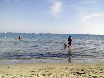 People on beach against sky