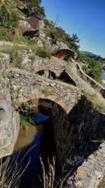 Arch bridge over river against sky