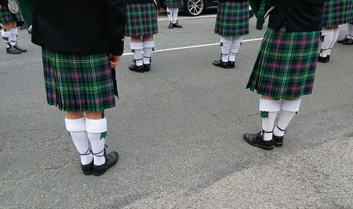 Low section of people in uniform standing on street