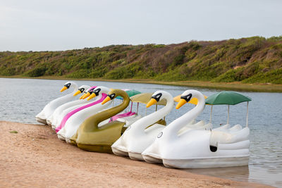 Deck chairs on shore at beach against sky