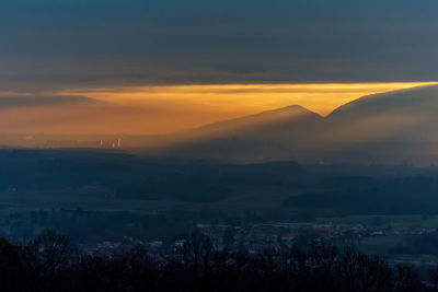 Scenic view of silhouette mountains against orange sky