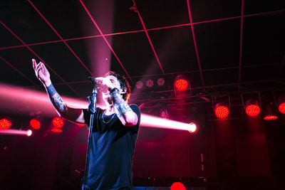 Man singing while standing on stage