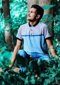 Boy looking away against plants
