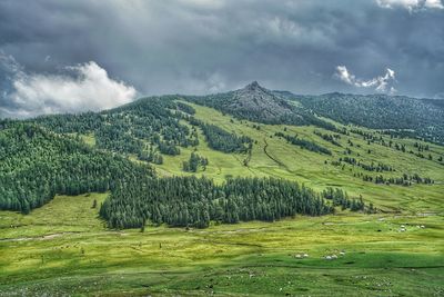 Scenic view of field and mountains against sky