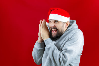 Portrait of man wearing hat against red background