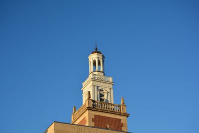 Low angle view of bell tower against clear blue sky