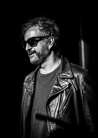 Portrait of man wearing sunglasses against black background