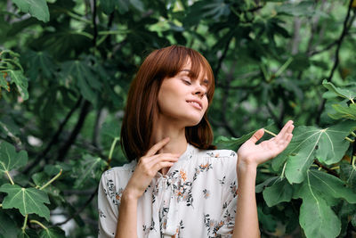 Portrait of young woman standing amidst plants