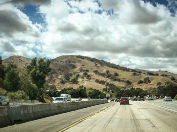 Road by mountain against sky