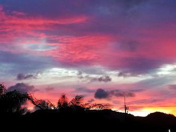 Low angle view of silhouette trees against dramatic sky