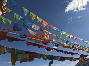 Low angle view of flags hanging against sky