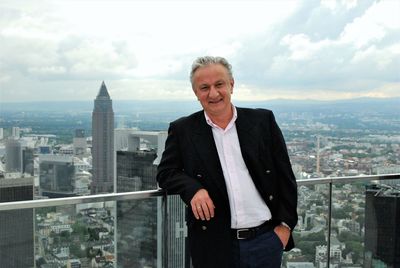 Portrait of businessman standing against sky