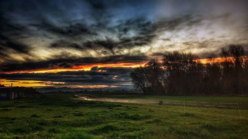 Scenic view of field against dramatic sky