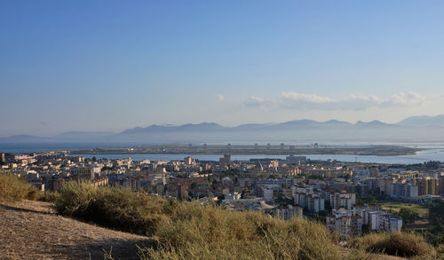 High angle view of townscape by sea against sky