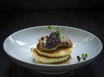 Close-up of pancakes with fried foie gras and onion marmalade on table