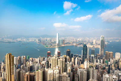 Aerial view of city buildings against cloudy sky