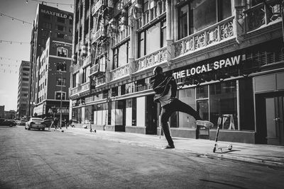 Woman on street against buildings in city