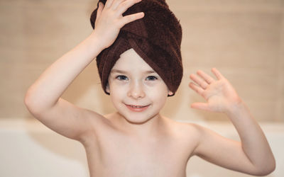 Joyful child in the bathroom with a towel on his head. children hygiene.