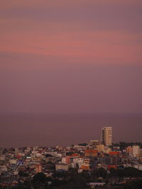 High angle view of townscape by sea against romantic sky