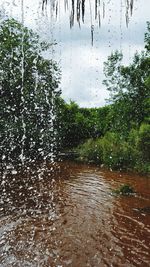 Wet lake against sky during rainy season