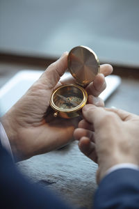 Businessman holding navigational compass at cafe