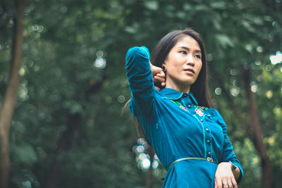Mid adult man looking away while standing in forest
