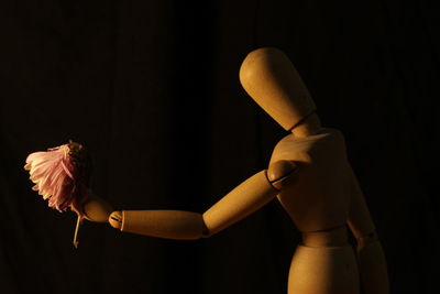 Close-up of wooden figurine against black background