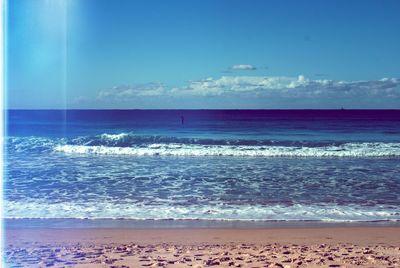 Scenic view of beach against blue sky