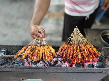 Low angle view of person preparing food on barbecue grill