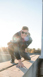 Low angle view of young man standing against clear sky